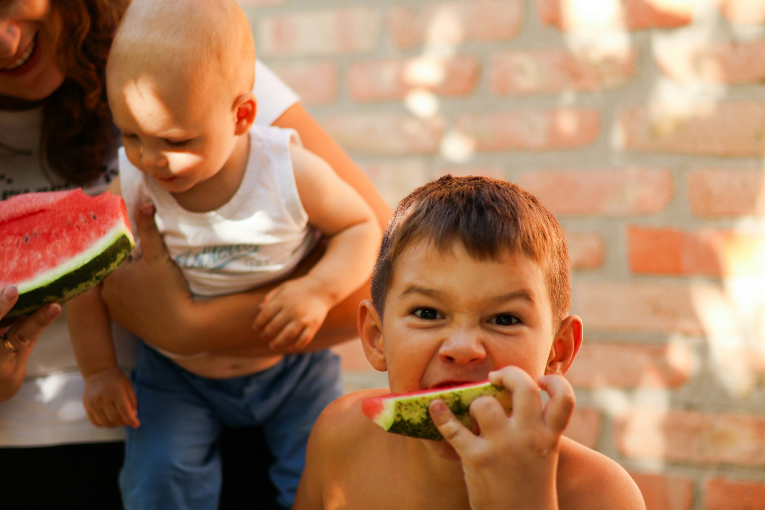 夏に屋外でスイカを頬張る子どもたち。近場でつくる夏の思い出のイメージ
